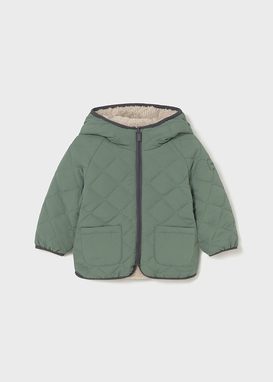 Green quilted jacket with a hood on a light gray background