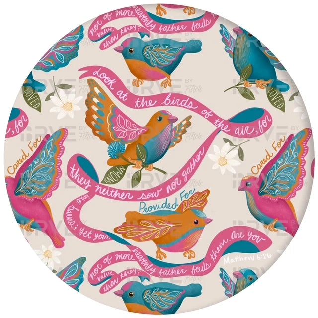 A round decorative plate or platter featuring a colorful repeating pattern of stylized birds in pink, teal, orange, and blue on a light cream background, with pink banners containing Bible verse text.