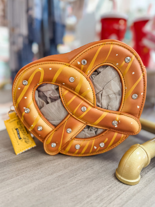 Pretzel-shaped bag with decorative elements on a table