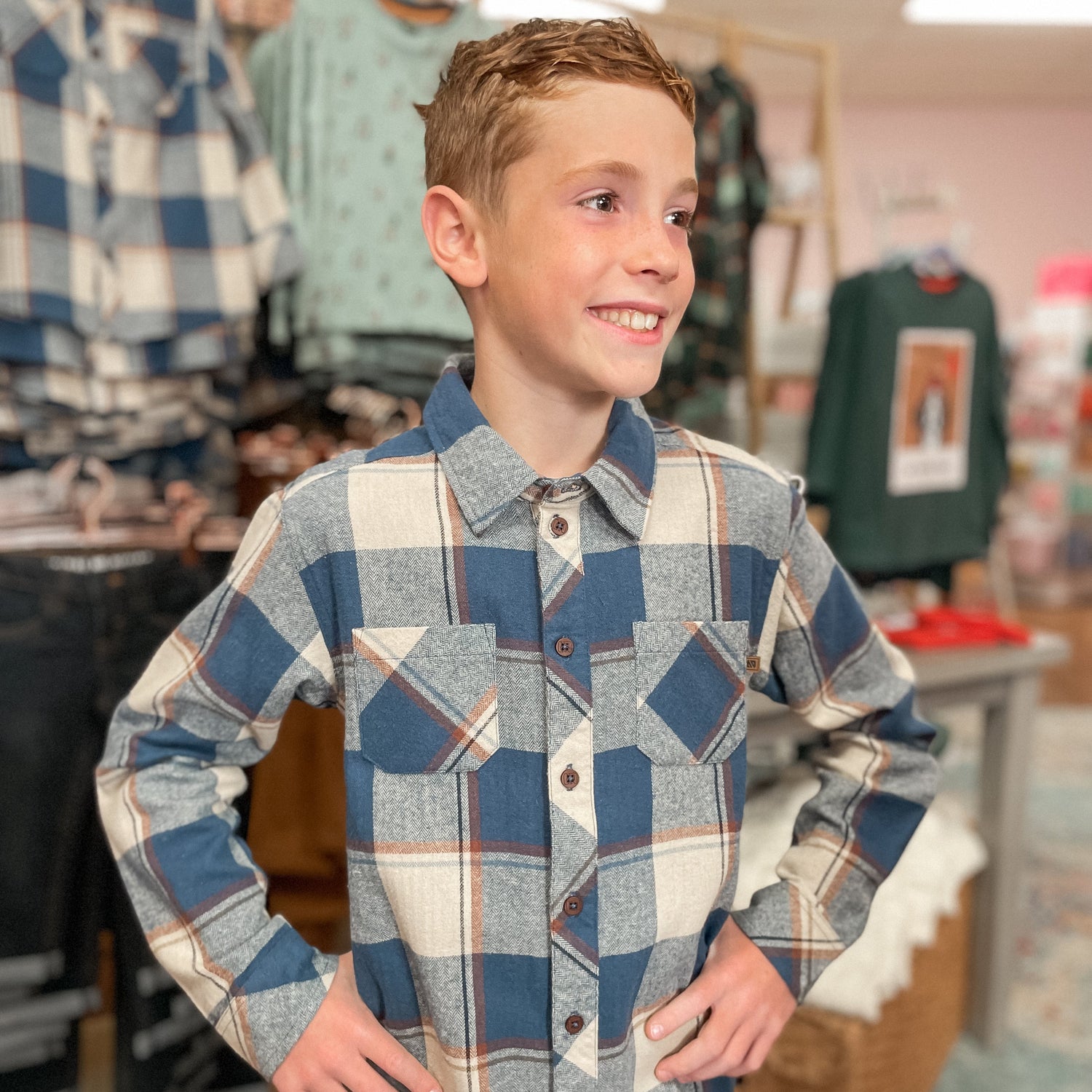 Young boy wearing a plaid shirt in a store setting
