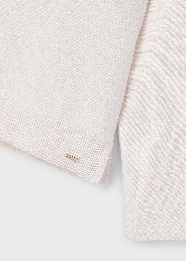 Close-up of a light-colored knit garment on a white background