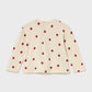 Beige sweater with red apple pattern on a white background