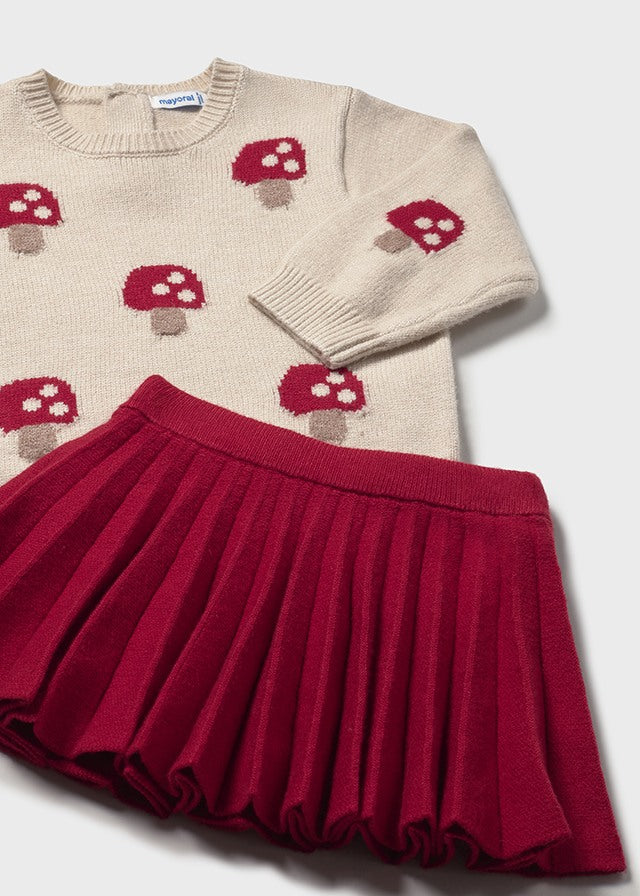 Children's sweater with mushroom pattern and red skirt on a white background