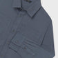 Blue shirt with button details on a light gray background