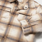 Folded plaid shirt on a light gray background