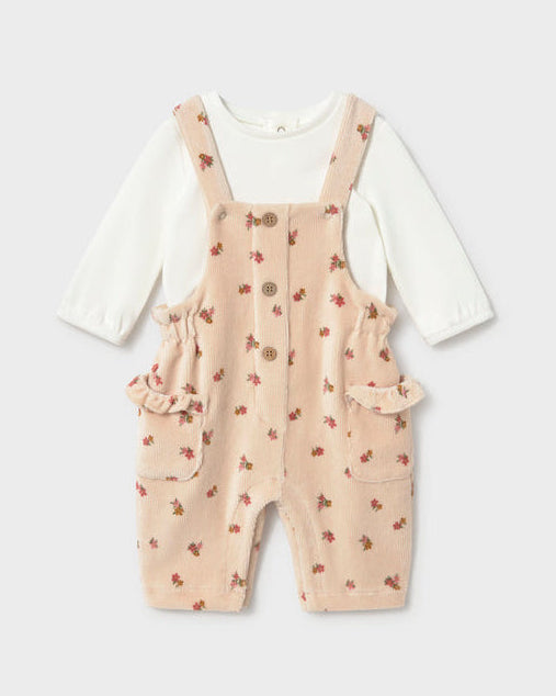 Cream corduroy overall set with white long sleeve top underneath. 