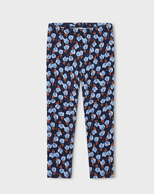 A pair of children's leggings with an all-over repeating pattern of light blue flowers on a dark navy background, shown flat against a light gray studio backdrop.