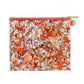 Glittery pouch with orange and white pattern on a white background