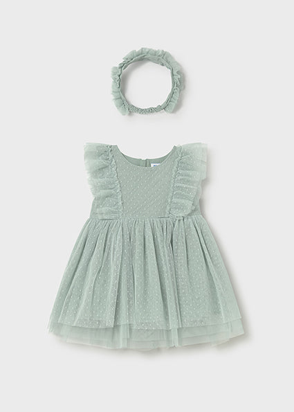 Light green baby dress with ruffled sleeves and matching headband on a light gray background