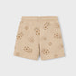 Beige shorts with soccer ball pattern on a tan background