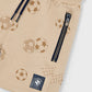 Beige shorts with soccer ball pattern and zipper on a tan background