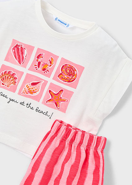 White shirt with pink shell and starfish designs and red striped pants on a white background