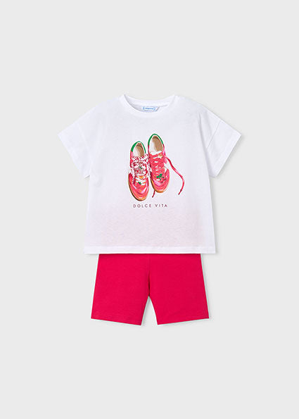 White t-shirt with red sneakers graphic and pink shorts on a white background