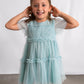 Young girl wearing a light blue dress against a white background