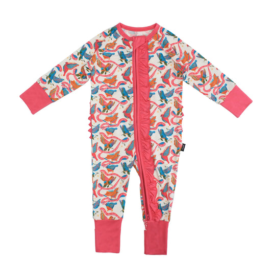 A baby long-sleeve footless one-piece jumpsuit with a colorful bird and snake pattern on a cream background, featuring bright pink ruffle trim down the front and matching pink cuffs and collar.