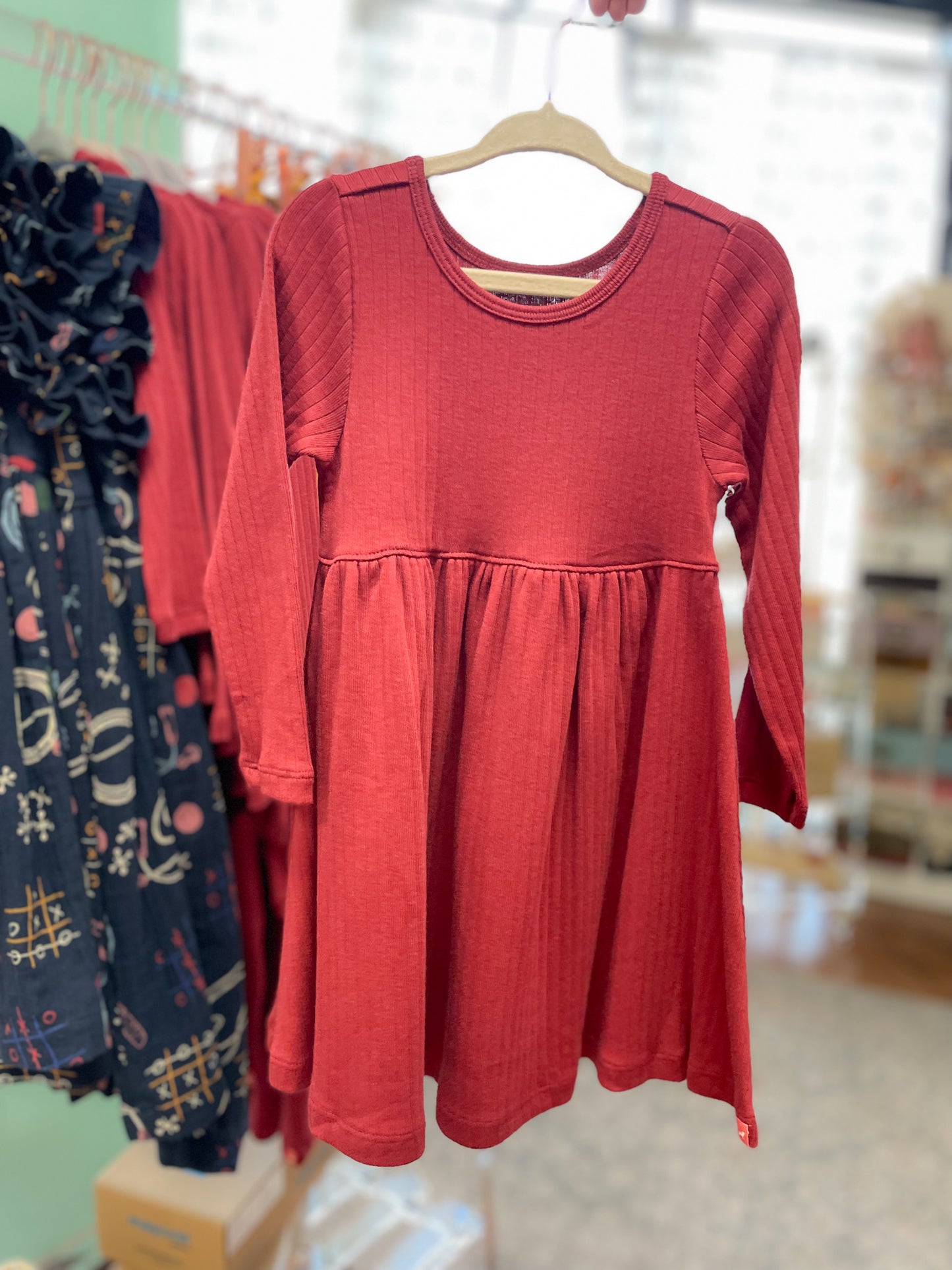 Red dress on a hanger with a blurred store background
