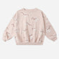 Pink sweatshirt with white poodle patterns on a white background. 