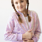 Young girl wearing a sparkly pink jacket on a white background