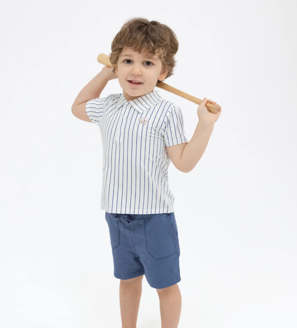 Child wearing a striped shirt and shorts holding a baseball bat on a white background