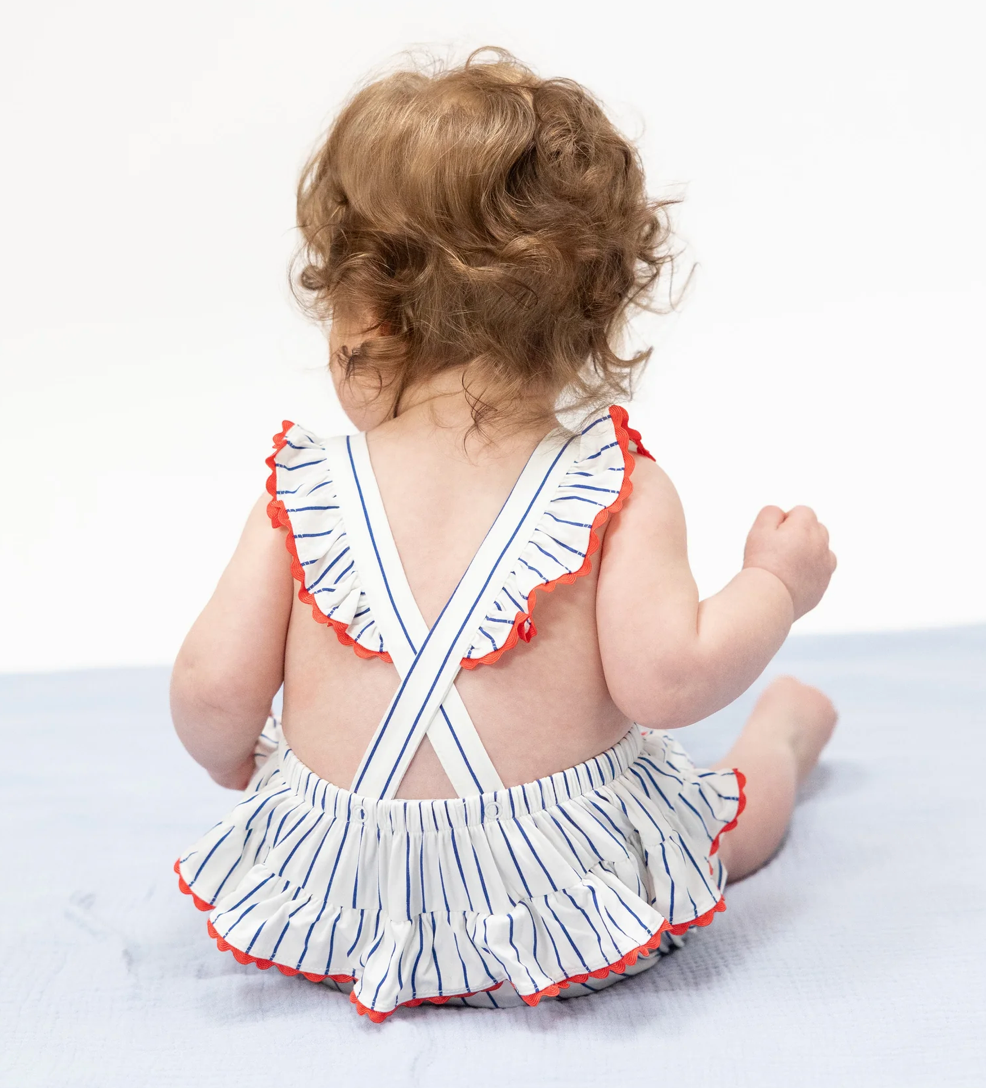 Baby wearing a striped swimsuit with ruffled details on a white background