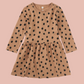 Brown dress with black polka dots on a white background