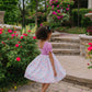 Young girl in a garden with pink flowers and stone steps