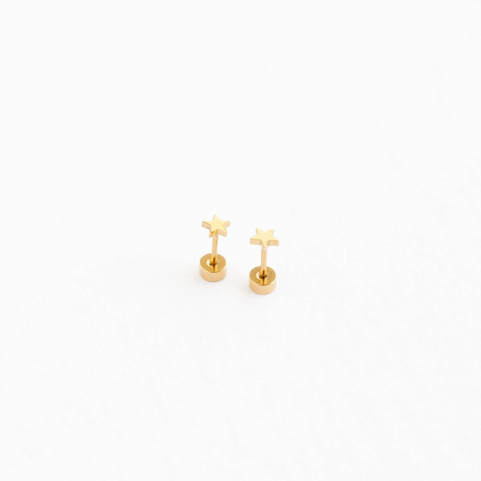 Gold star earrings on a white background
