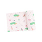A folded pink swaddle blanket with a golf-themed pattern including illustrations of golf balls, tees, and holes.