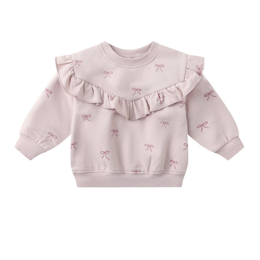 Pink baby sweater with ruffled details on a white background